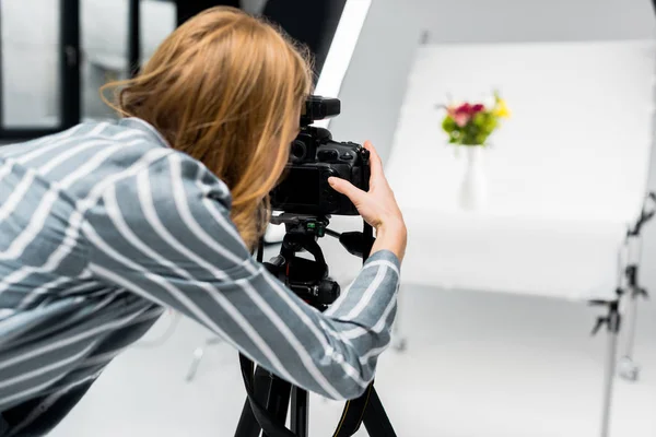 Mujer joven disparando hermosas flores en estudio fotográfico profesional - foto de stock