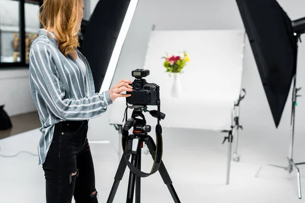 Tiro cortado de jovem fotógrafo do sexo feminino atirando flores em estúdio — Fotografia de Stock