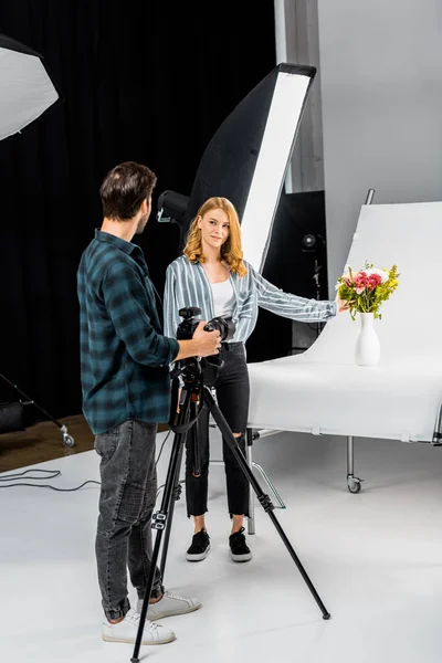 Jeunes photographes se regardant tout en filmant des fleurs en studio — Photo de stock