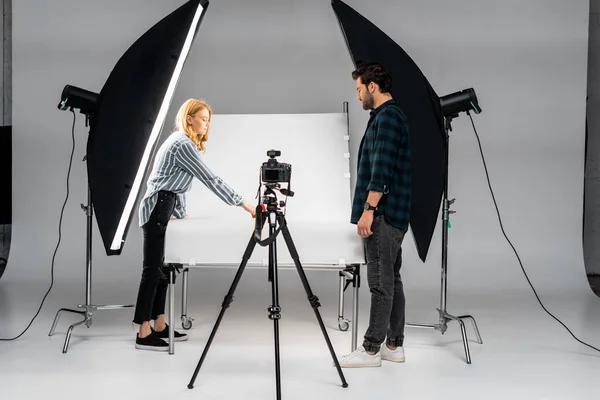 Jovens fotógrafos que trabalham com equipamentos profissionais em estúdio de fotografia — Fotografia de Stock