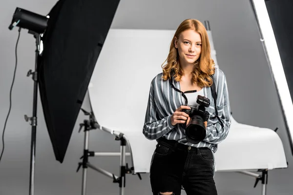 Bela jovem fotógrafa trabalhando no estúdio de fotografia profissional — Fotografia de Stock