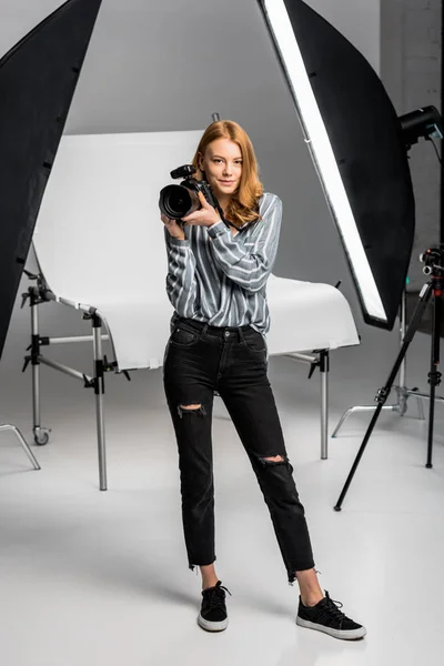 Beautiful female photographer working in professional photo studio — Stock Photo