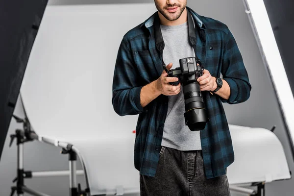 Обрізаний знімок професійного молодого фотографа, який використовує камеру в фотостудії — стокове фото