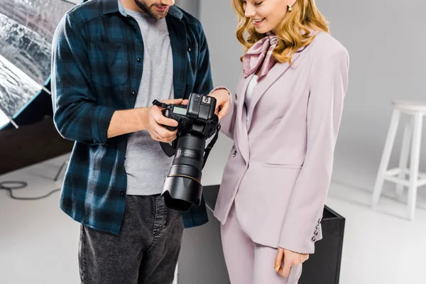 Tiro recortado de sorrindo jovem fotógrafo e modelo usando câmera de fotos juntos — Fotografia de Stock