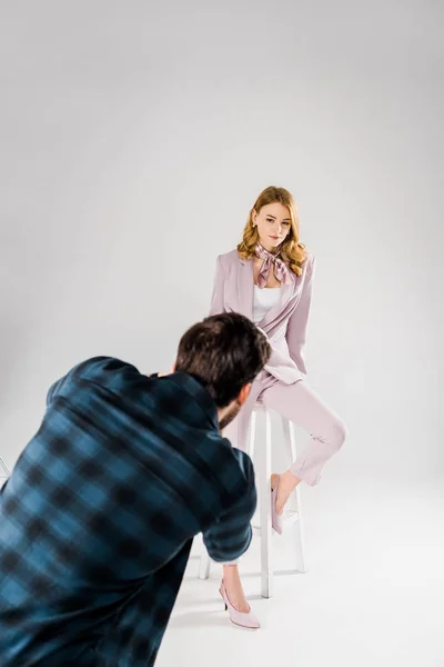 Vue arrière du photographe qui travaille avec une belle jeune mannequin féminine en studio photo — Photo de stock