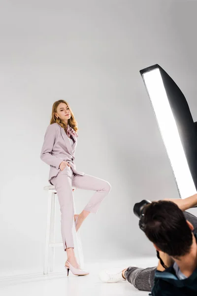 Cropped shot of photographer lying and photographing beautiful young woman in photo studio — Stock Photo