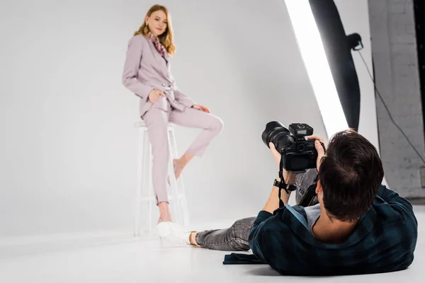 Fotógrafo mentir e fotografar bela modelo feminina posando em estúdio — Fotografia de Stock