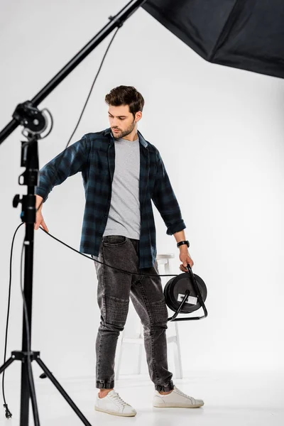Young photographer working with photo equipment in professional studio — Stock Photo