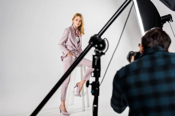 Cropped shot of photographer shooting beautiful female model in photo studio — Stock Photo