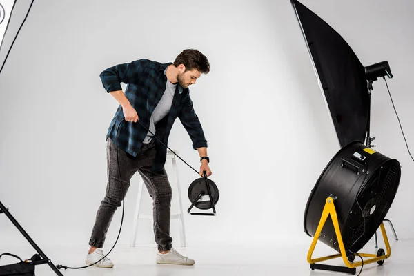 Young man working with equipment in professional photo studio — Stock Photo