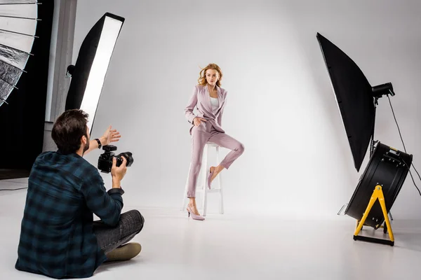 Young photographer shooting beautiful stylish young woman in photo studio — Stock Photo