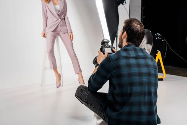 Plan recadré de photographe tirant belle jeune mannequin femelle en studio — Photo de stock