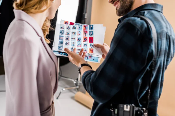 Cropped shot of photographer and model looking at photos in studio — Stock Photo
