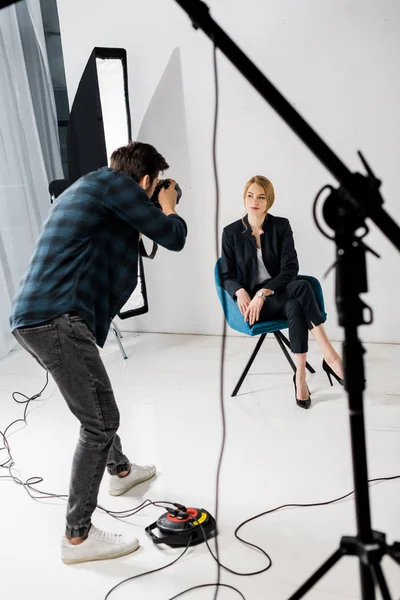 Young man photographing beautiful female model in photo studio — Stock Photo