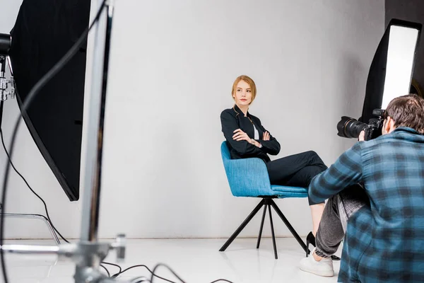 Photographer shooting beautiful young woman in photo studio — Stock Photo