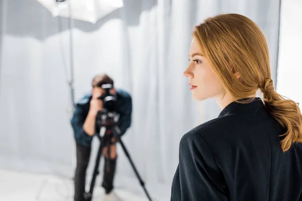 Vista close-up de belo jovem modelo e fotógrafo trabalhando para trás no estúdio — Fotografia de Stock