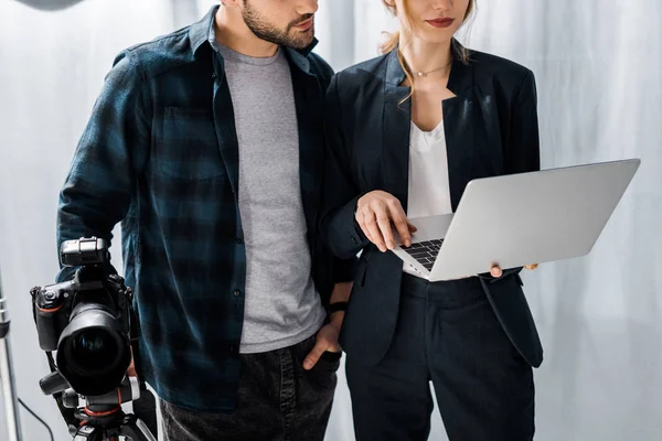 Plan recadré du photographe et du modèle à l'aide d'un ordinateur portable en studio — Photo de stock