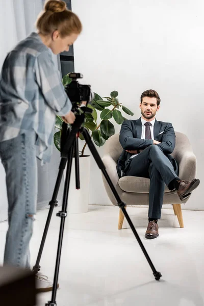 Young photographer taking pictures of handsome male model in studio — Stock Photo