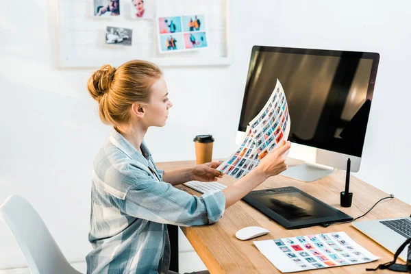 High angle view of attractive young photographer working with pictures in office — Stock Photo