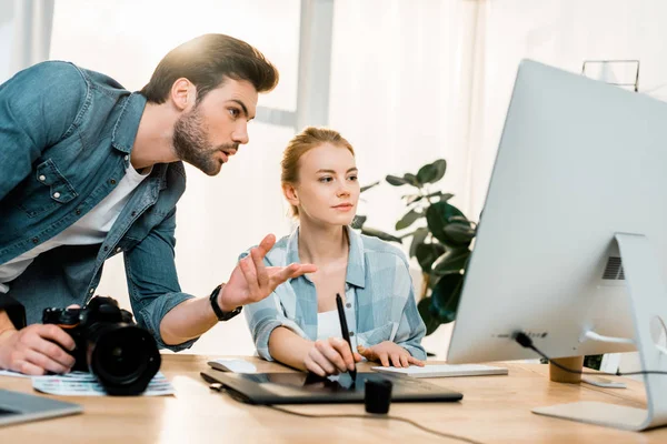 Professionelle junge Fotografen mit digitalen Geräten und Retuschen von Fotos im Büro — Stockfoto