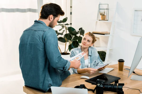 Junge Fotografen diskutieren und prüfen Fotos auf Retusche am Arbeitsplatz — Stockfoto