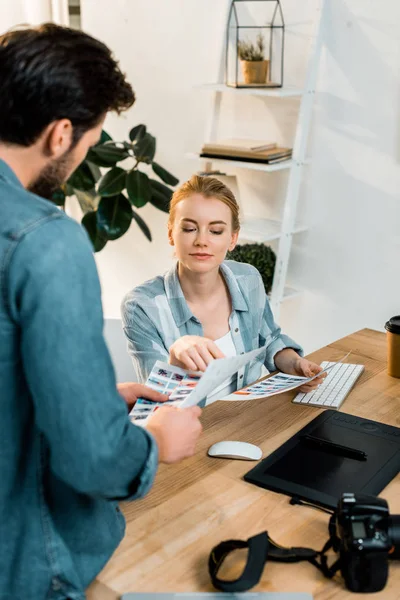 Plan recadré de jeunes photographes discutant et retouchant des photos au bureau — Photo de stock