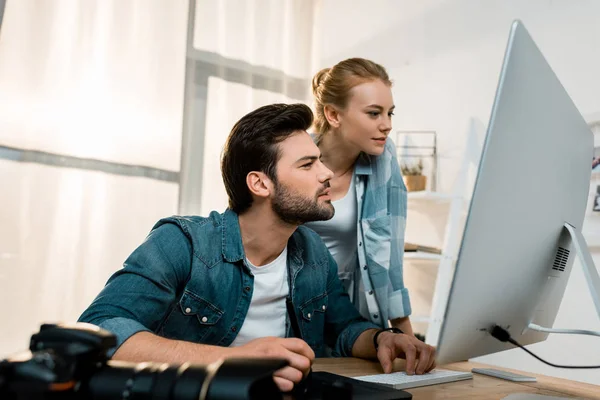 Fokussierte junge Designer, die mit Desktop-Computer und Zeichentablett arbeiten — Stockfoto