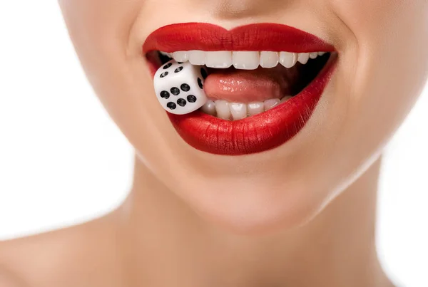 Close-up partial view of young woman holding dice in teeth isolated on white — Stock Photo