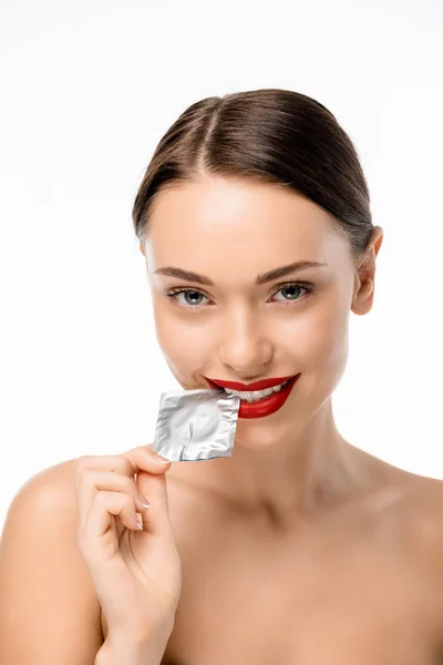 Bela menina nua segurando preservativo e sorrindo para a câmera isolada no branco — Fotografia de Stock