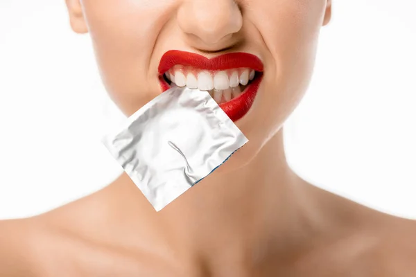 Cropped shot of young woman holding condom in teeth isolated on white — Stock Photo