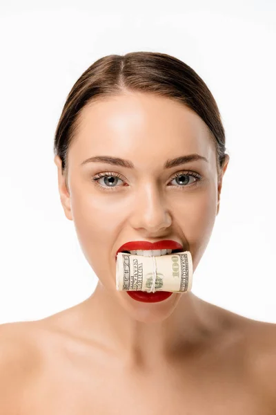 Hermosa mujer joven sosteniendo billetes de dólar enrollados en los dientes y mirando a la cámara aislada en blanco - foto de stock