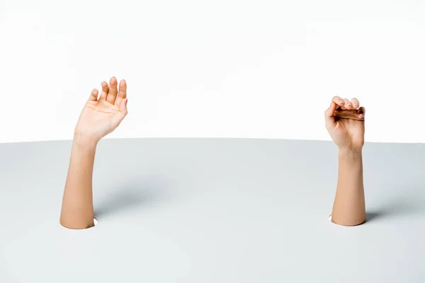 Plan recadré de mains féminines à travers des trous sur fond blanc — Photo de stock