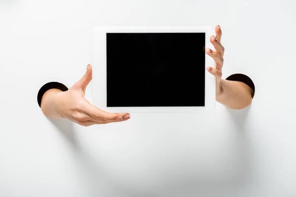 Image recadrée de la femme tenant tablette avec écran blanc à travers des trous sur blanc — Photo de stock