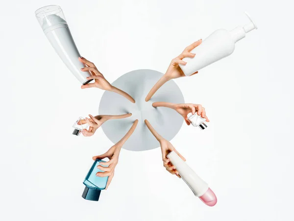 Abgeschnittene Bild von Frauen mit Flaschen Creme, Lotion und Parfüm isoliert auf weiß — Stockfoto