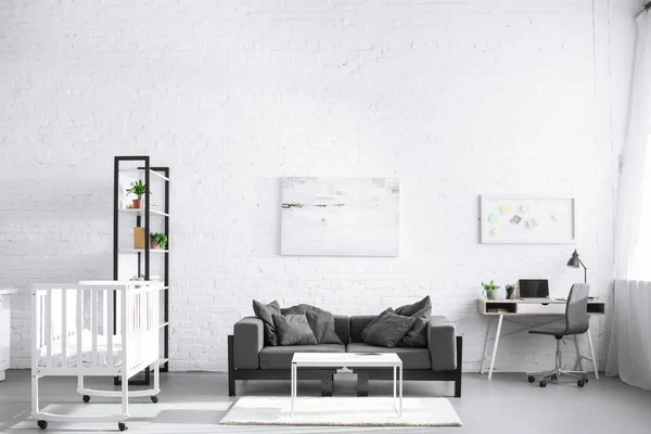 Moderno interior de la sala de estar con cuna y sofá - foto de stock