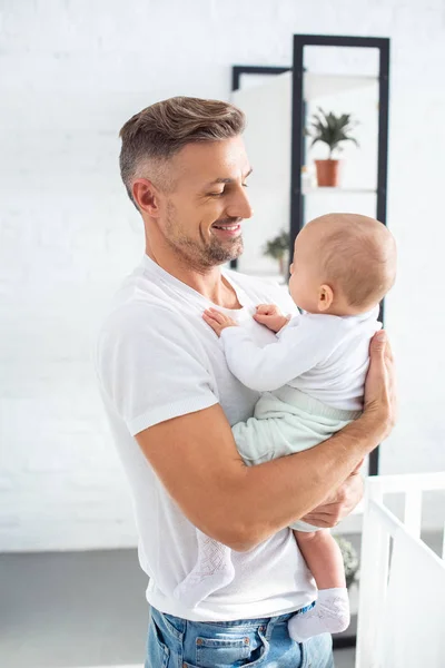 Vater schaut kleine Tochter an und lächelt zu Hause — Stockfoto