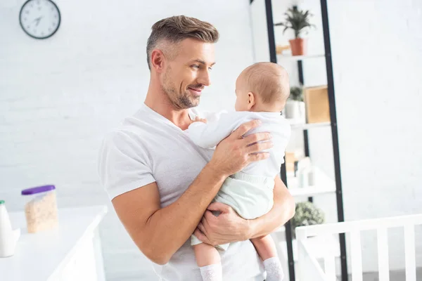 Pai alegre segurando bebê filha em casa — Fotografia de Stock