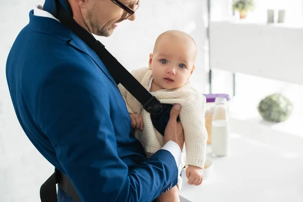 Filha bebê em babycarrier com pai em terno — Fotografia de Stock