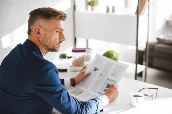 Selective focus of confident businessman holding business newspaper — Stock Photo