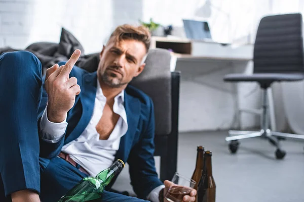 Selective focus of middle finger of drunk businessman in living room — Stock Photo