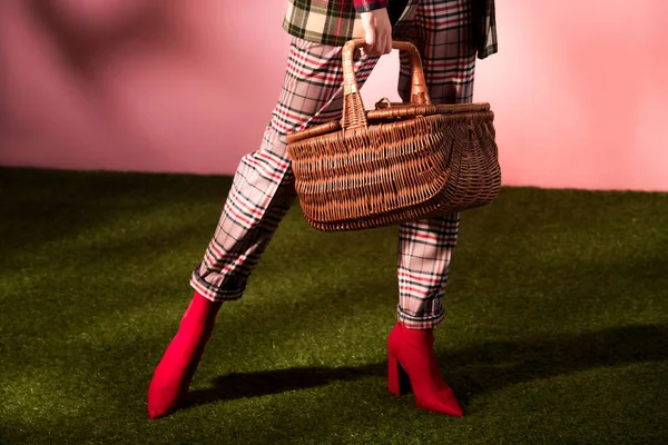 Vista de sección baja de chica con estilo en traje a cuadros de otoño posando con la cesta - foto de stock