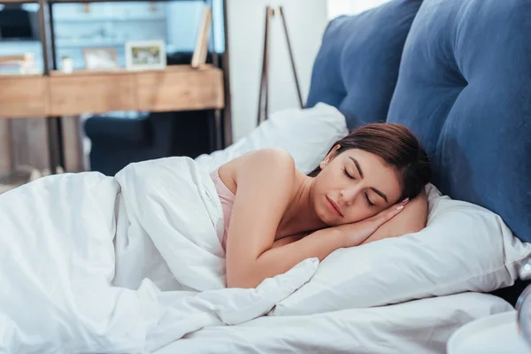 Joven hermosa mujer durmiendo en su cama durante la mañana en casa — Stock Photo