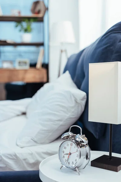 Selektive Fokussierung von Wecker und Lampe im heimischen Schlafzimmer — Stockfoto