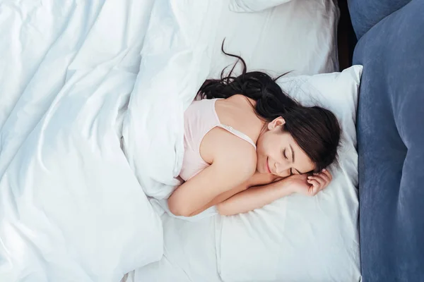 Vue grand angle de fille attrayante dormant dans son lit pendant le matin à la maison — Photo de stock
