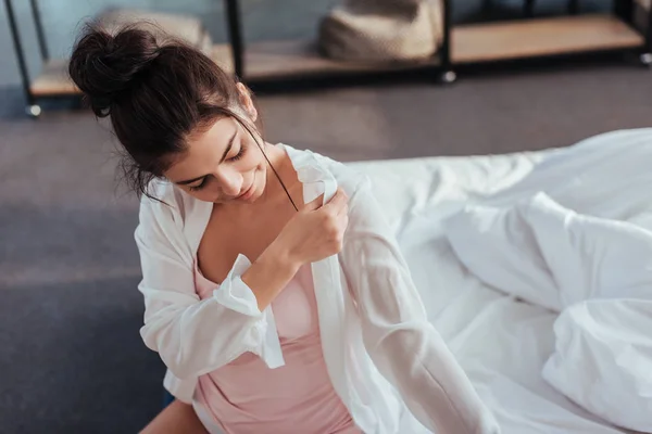 Hochwinkel-Ansicht der schönen Frau, die morgens zu Hause ein weißes Hemd anzieht — Stockfoto