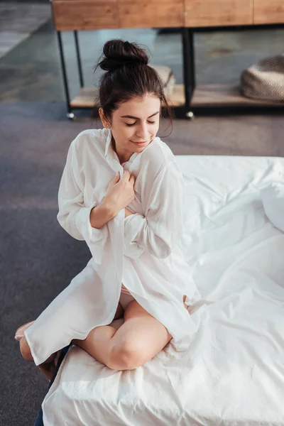 High angle view of pretty girl putting on white shirt during morning time at home — Stock Photo