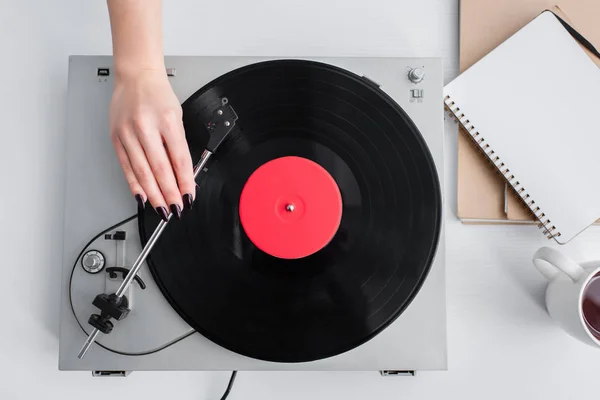 Cropped view of woman playing vinyl record on vintage player — Stock Photo