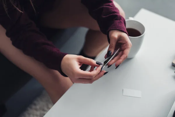 Vue recadrée de fille assise et rouler joint de marijuana à la maison — Photo de stock