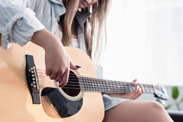 Vista cortada de músico tocando guitarra acústica em casa — Fotografia de Stock