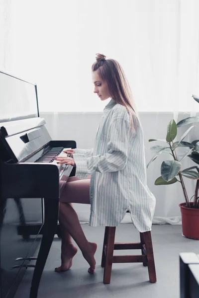 Vista laterale del bellissimo musicista che suona il pianoforte a casa — Foto stock